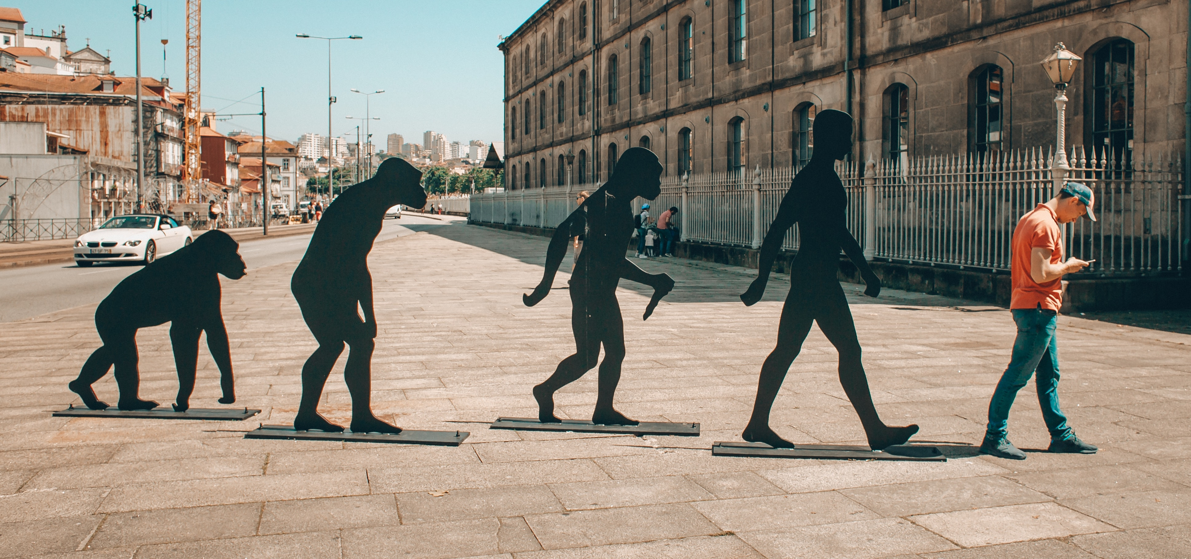 Person using phone next to 'Evolutionary Steps' sculpture.